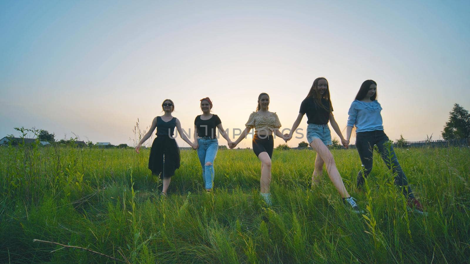 Girls walk at sunset on a warm summer evening