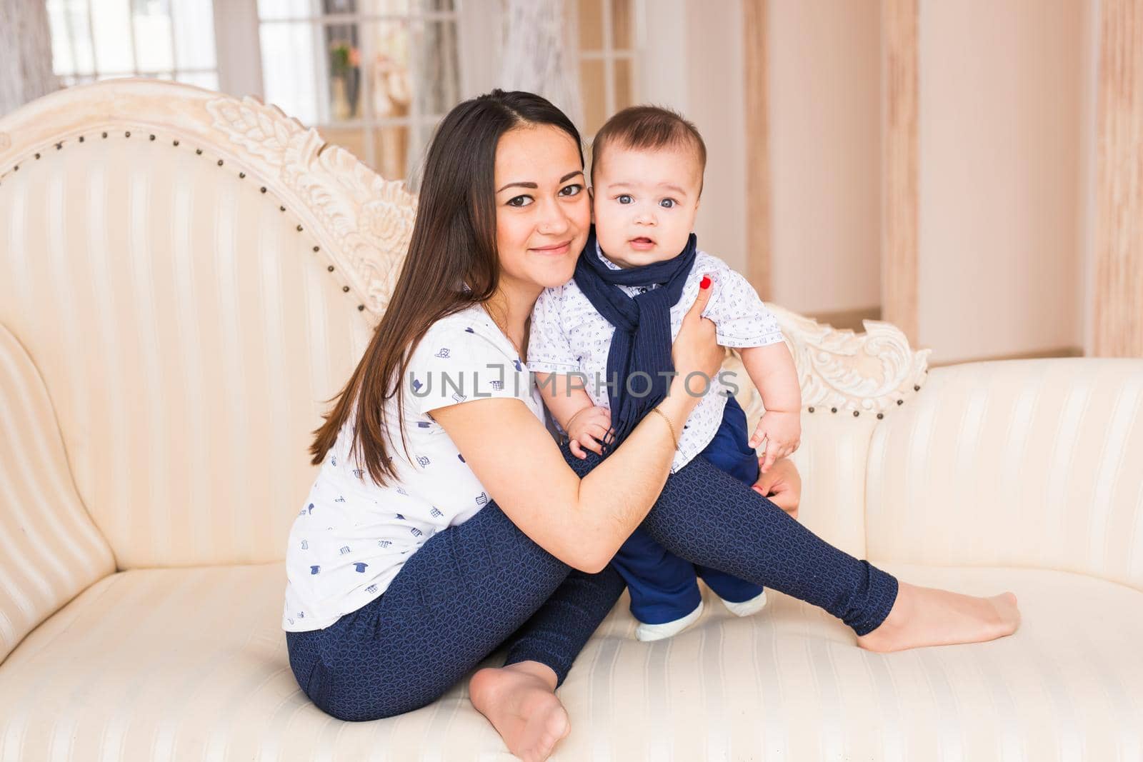 Portrait of young mother with cute baby at home.