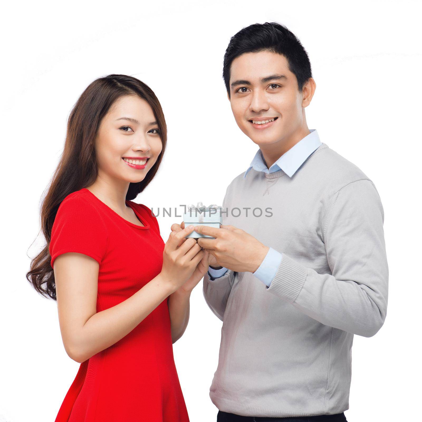 Asian man makes present to his lovely sweetheart. Young man giving a gift. Cheerful young couple man and woman at home offering to each other gifts for lover's valentine day