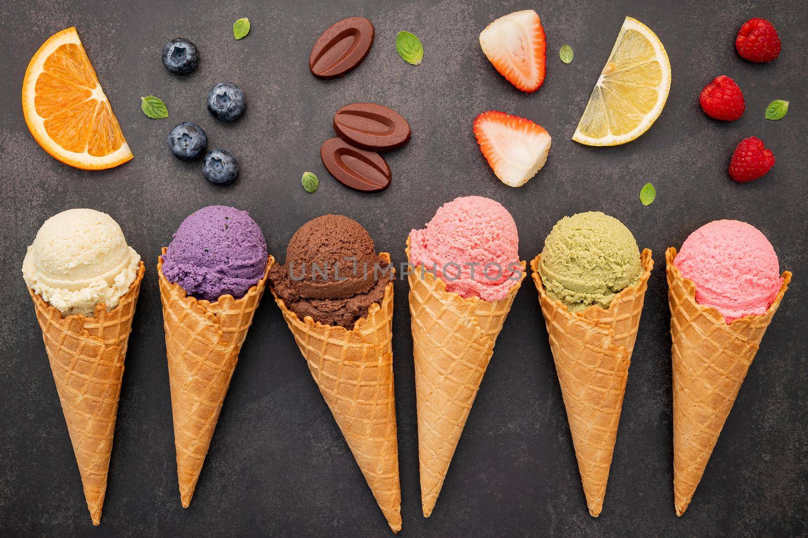 Flat lay ice cream cones collection on dark stone background . Blank crispy ice cream cone with copy space for sweets menu design. by kerdkanno