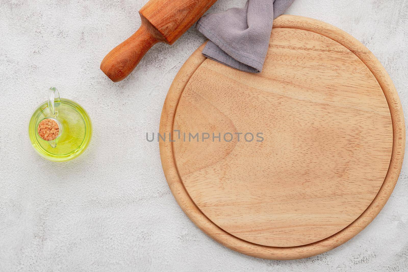 Empty wooden pizza platter set up on white concrete. Pizza board on white concrete background flat lay and copy space. by kerdkanno