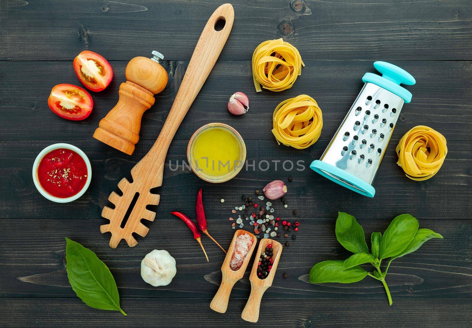 The  pasta on black wooden background. Yellow italian pasta with ingredients. Italian food and menu concept.