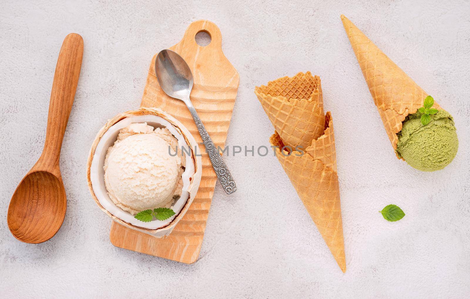 Coconut ice cream flavours in half of coconut setup on white stone background. Summer and Sweet menu concept. by kerdkanno