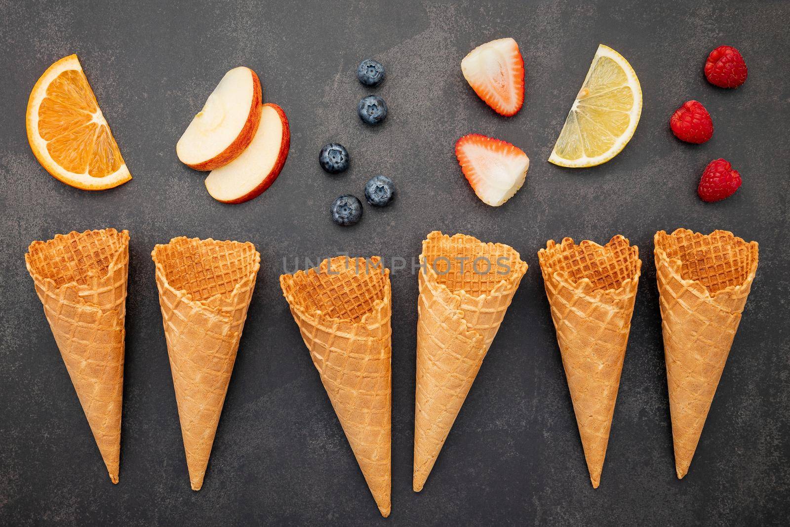 Flat lay ice cream cones collection on dark stone background . Blank crispy ice cream cone with copy space for sweets menu design. by kerdkanno