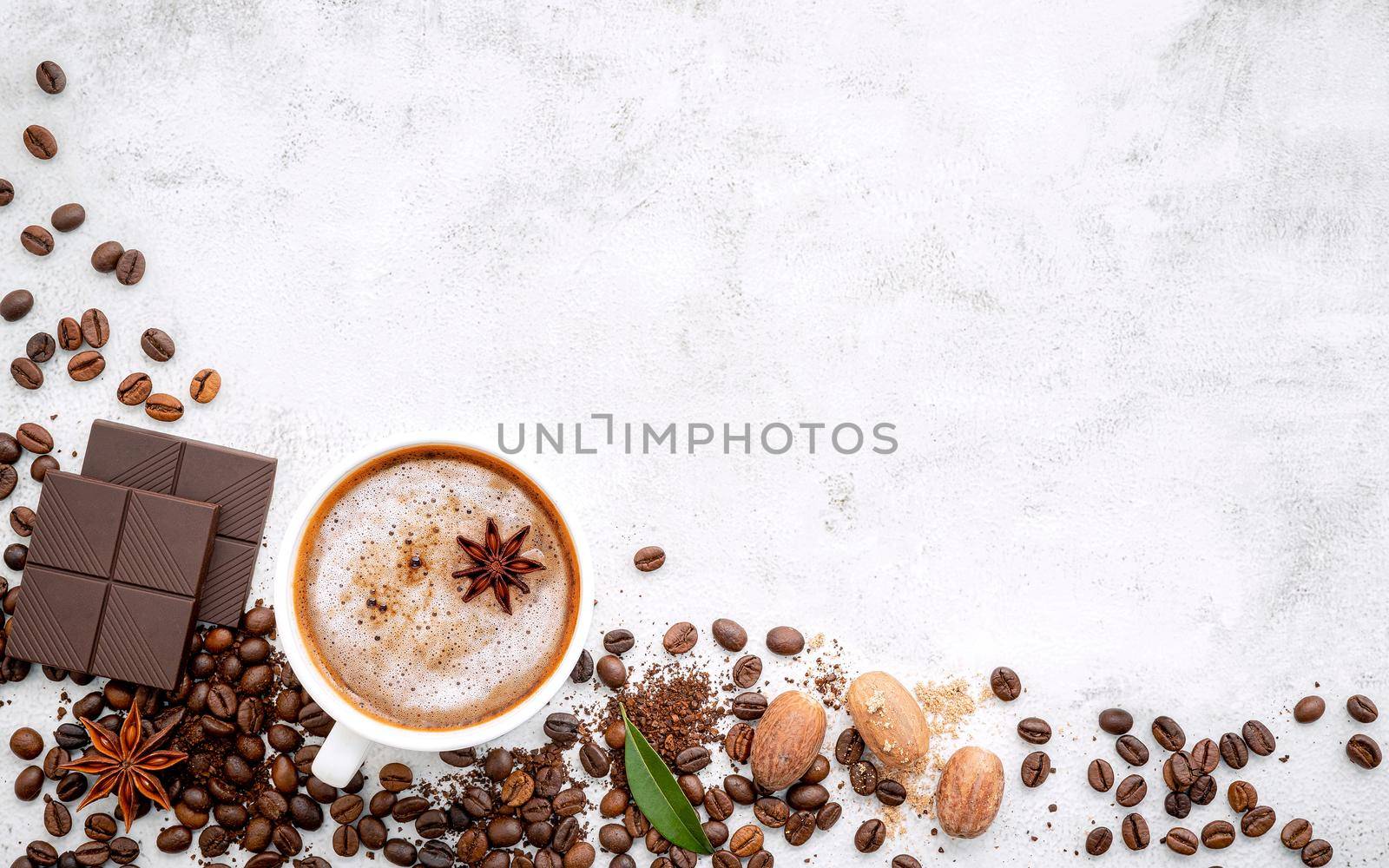 Background of dark roasted coffee bean and with dark chocolate on white concrete background with copy space.