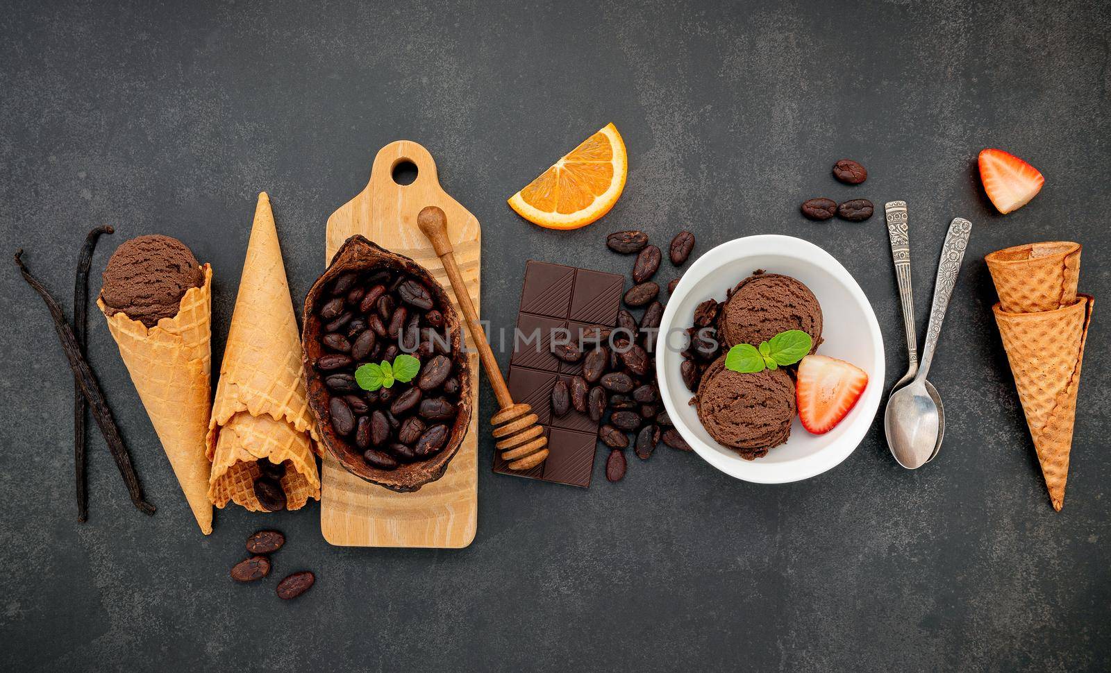 Chocolate ice cream flavours in bowl with dark chocolate and cacao nibs setup on dark stone background . by kerdkanno