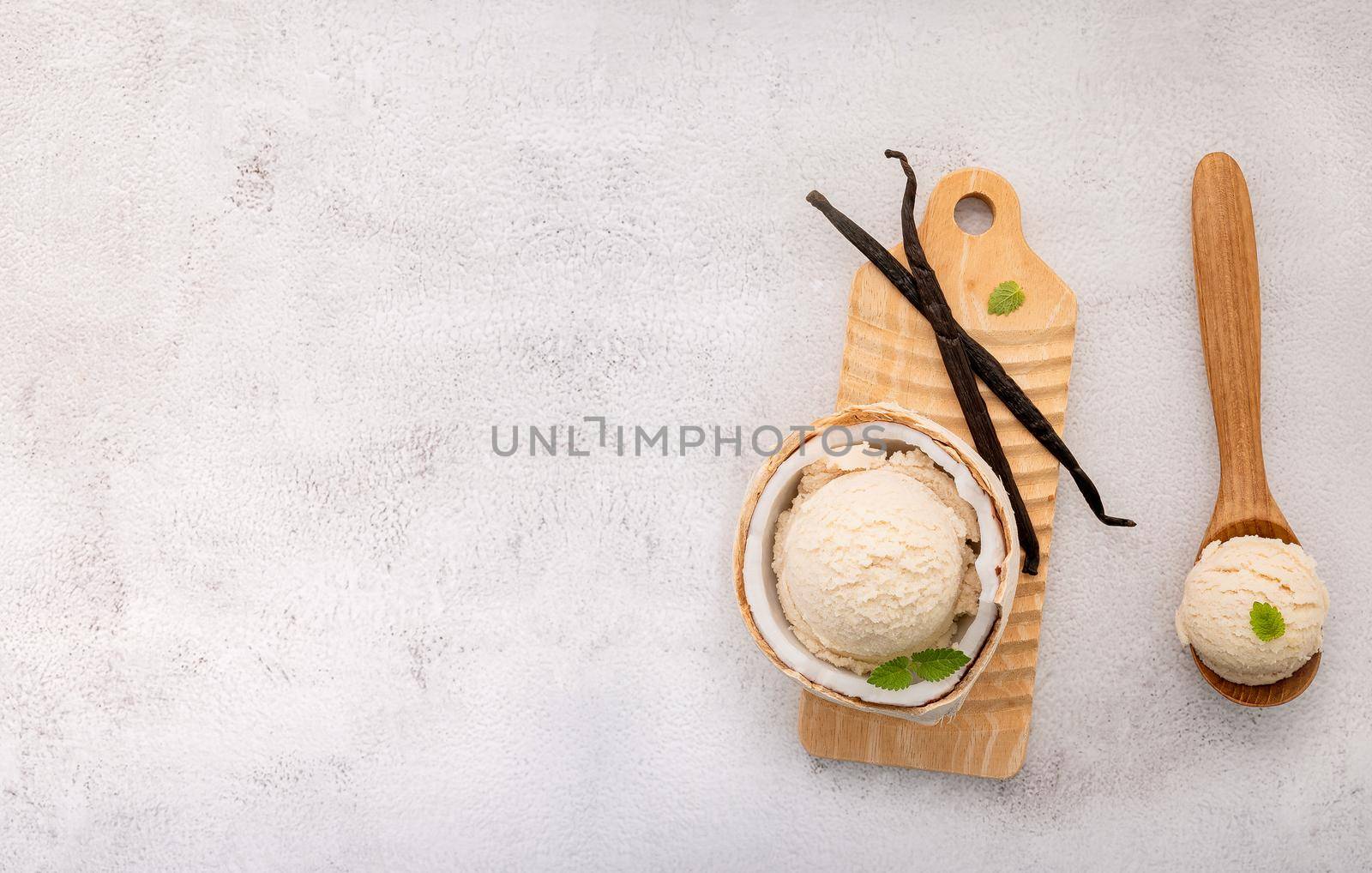 Coconut ice cream flavours in half of coconut setup on white stone background. Summer and Sweet menu concept.