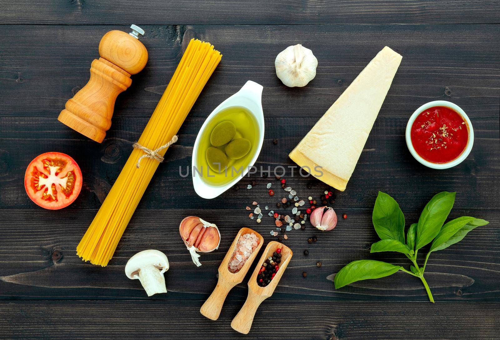 The  pasta on black wooden background. Yellow italian pasta with ingredients. Italian food and menu concept. by kerdkanno