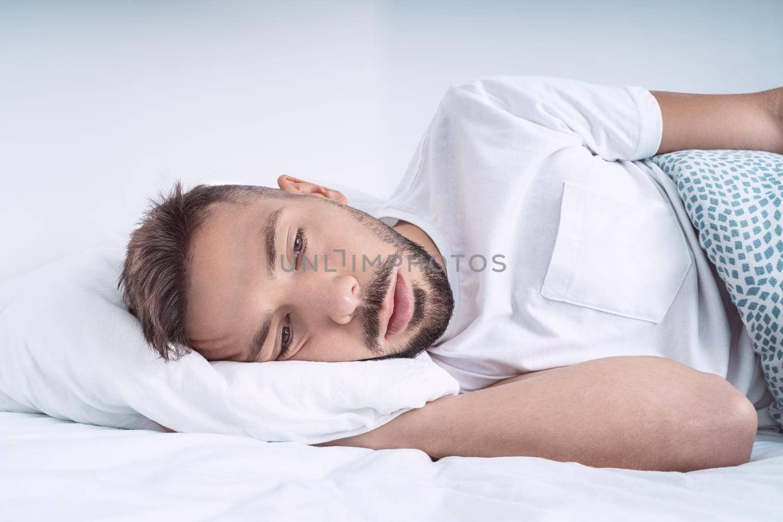 Stressed and depressed man lying in the bed. Man feeling bad, desperate and helpless. High quality photo