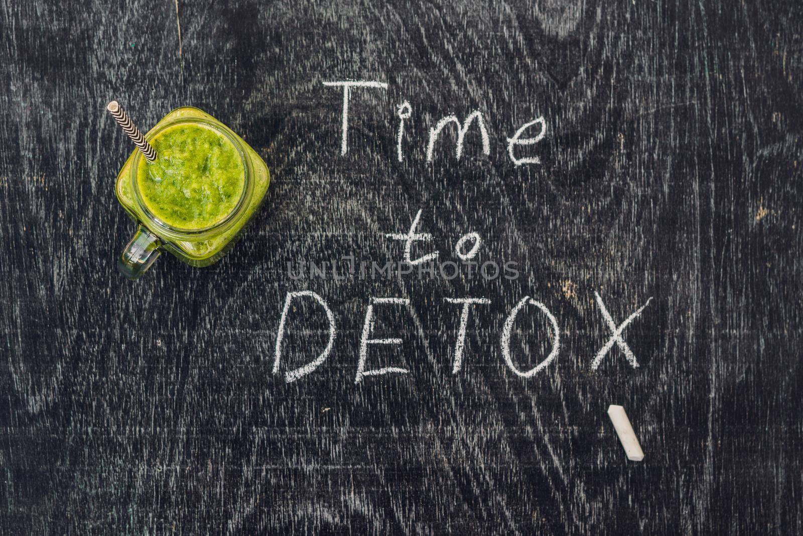 TIME TO DETOX chalk inscription on the wooden table and Green smoothies made of spinach. Healthy eating and sports concept.