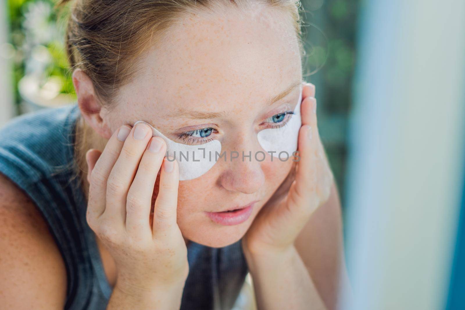 Portrait of Beauty Red-haired woman with eye patches showing an effect of perfect skin. Spa Girl by galitskaya