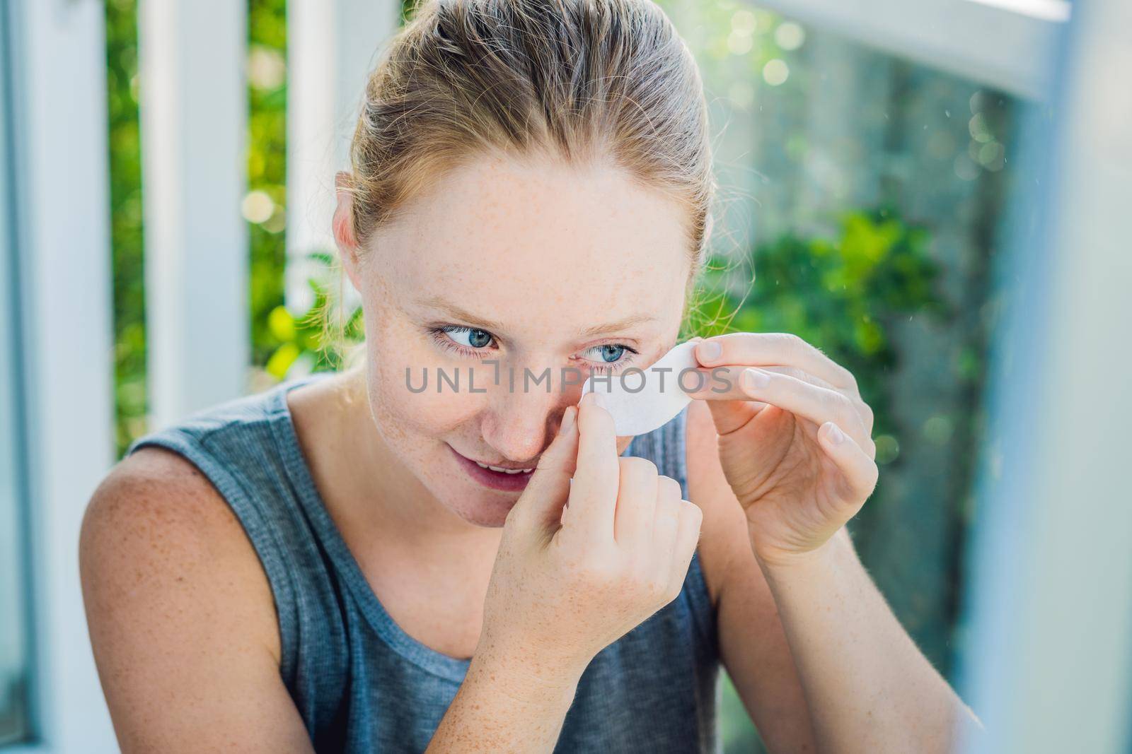 Portrait of Beauty Red-haired woman with eye patches showing an effect of perfect skin. Spa Girl.