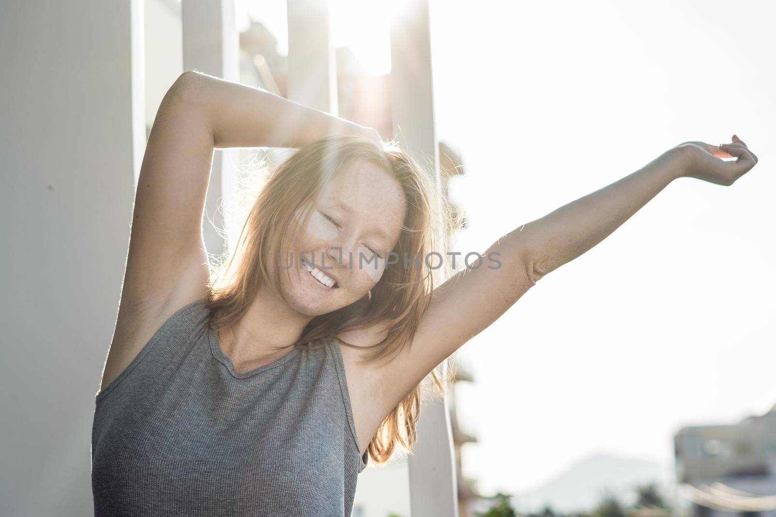 Portrait of Beauty Red-haired woman with eye patches showing an effect of perfect skin. Spa Girl.