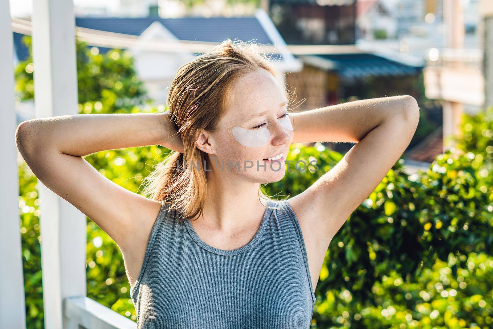 Portrait of Beauty Red-haired woman with eye patches showing an effect of perfect skin. Spa Girl.