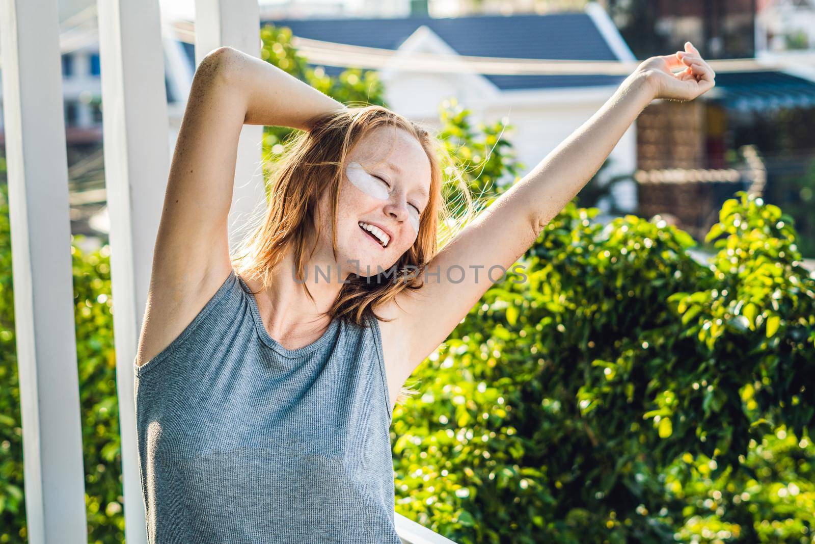 Portrait of Beauty Red-haired woman with eye patches showing an effect of perfect skin. Spa Girl.