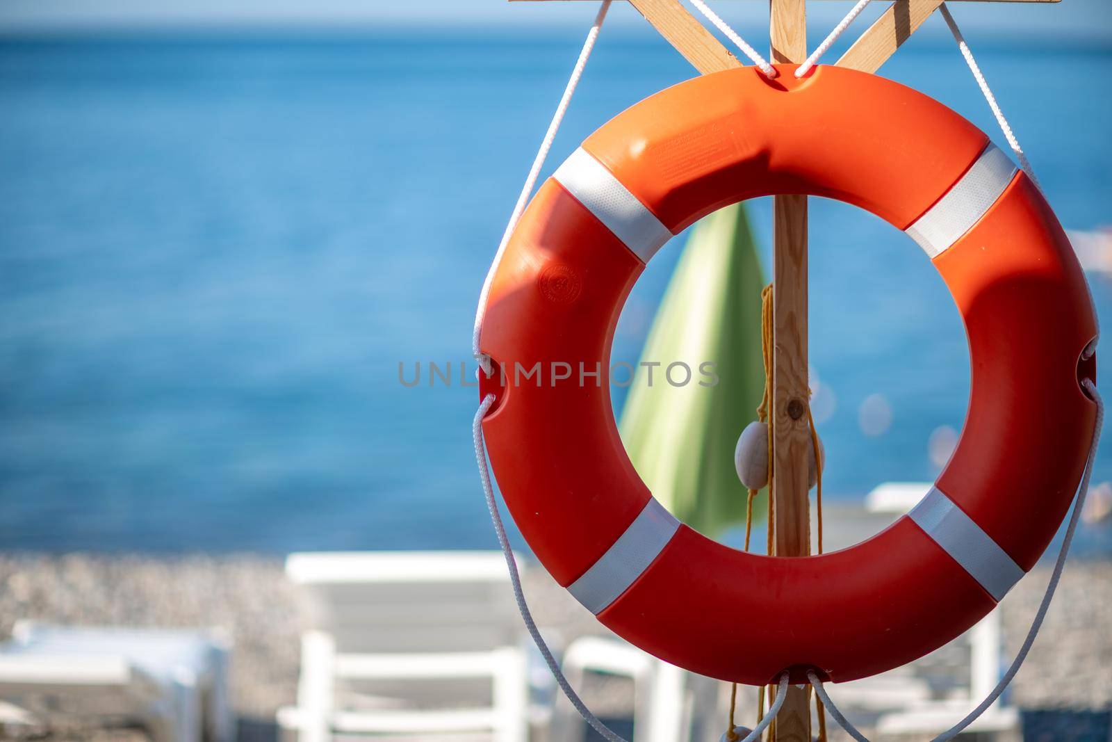 Several white sun loungers and a life buoy on a deserted beach. The perfect vacation concept.