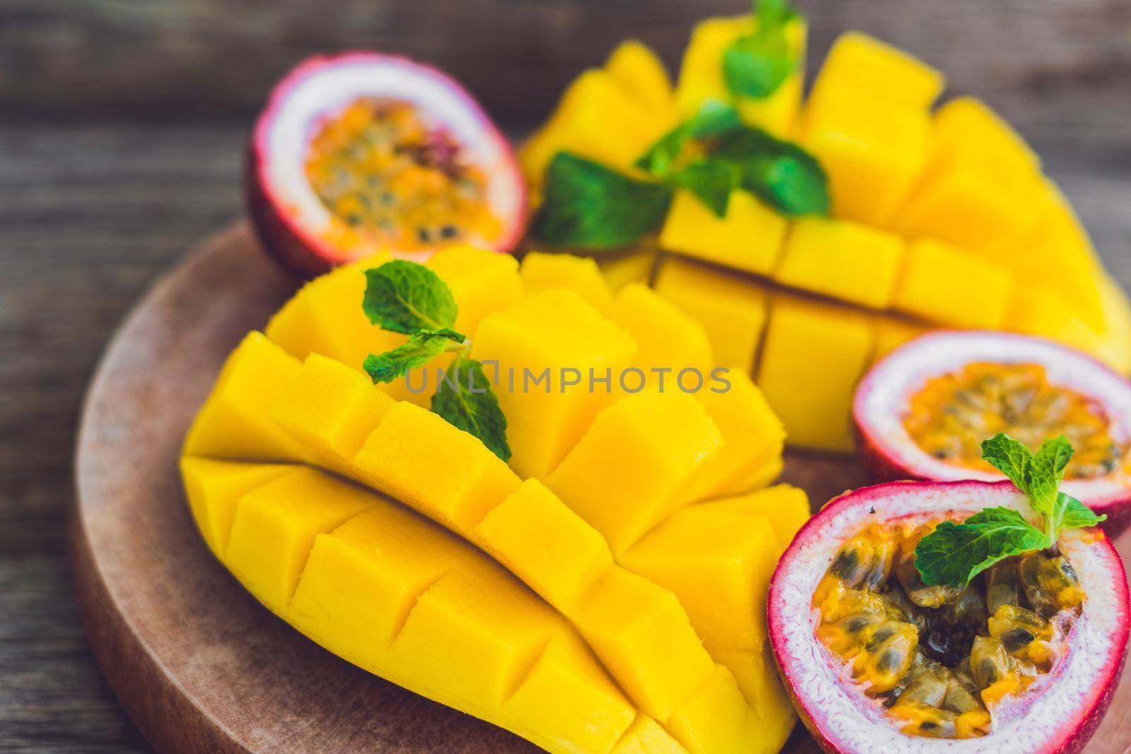 Mango and passion fruit on an old wooden background by galitskaya