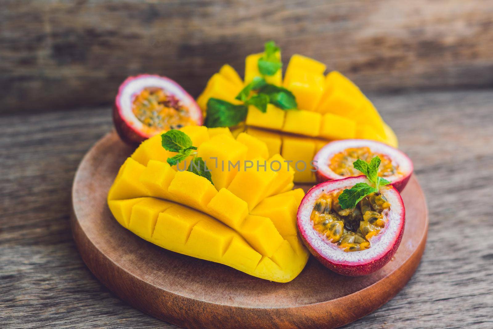 Mango and passion fruit on an old wooden background by galitskaya