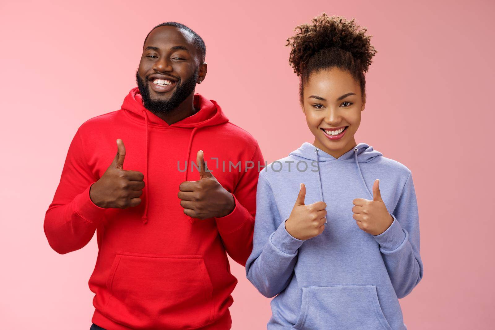 Best friends support your choice. Portrait proud satisfied good-looking african-american man woman show camera thumbs-up smiling broadly cheering liking awesome purchase, standing pink background.