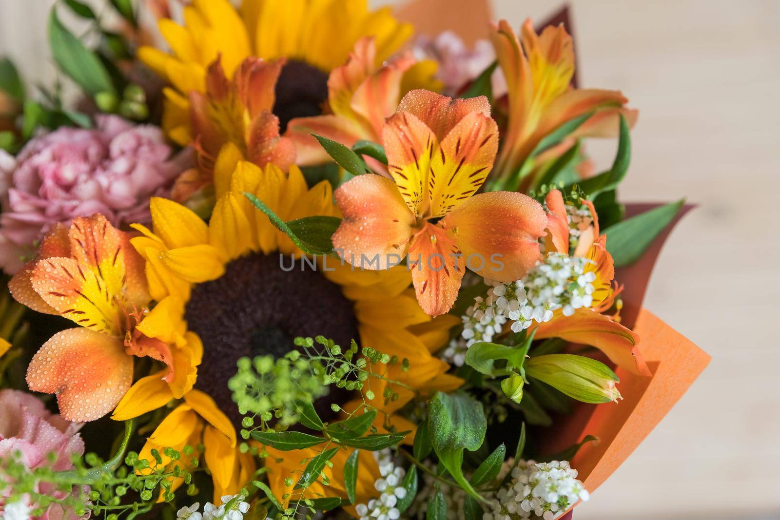 Fresh Bouquet of yellow sunflowers and pink carnations with white wood background