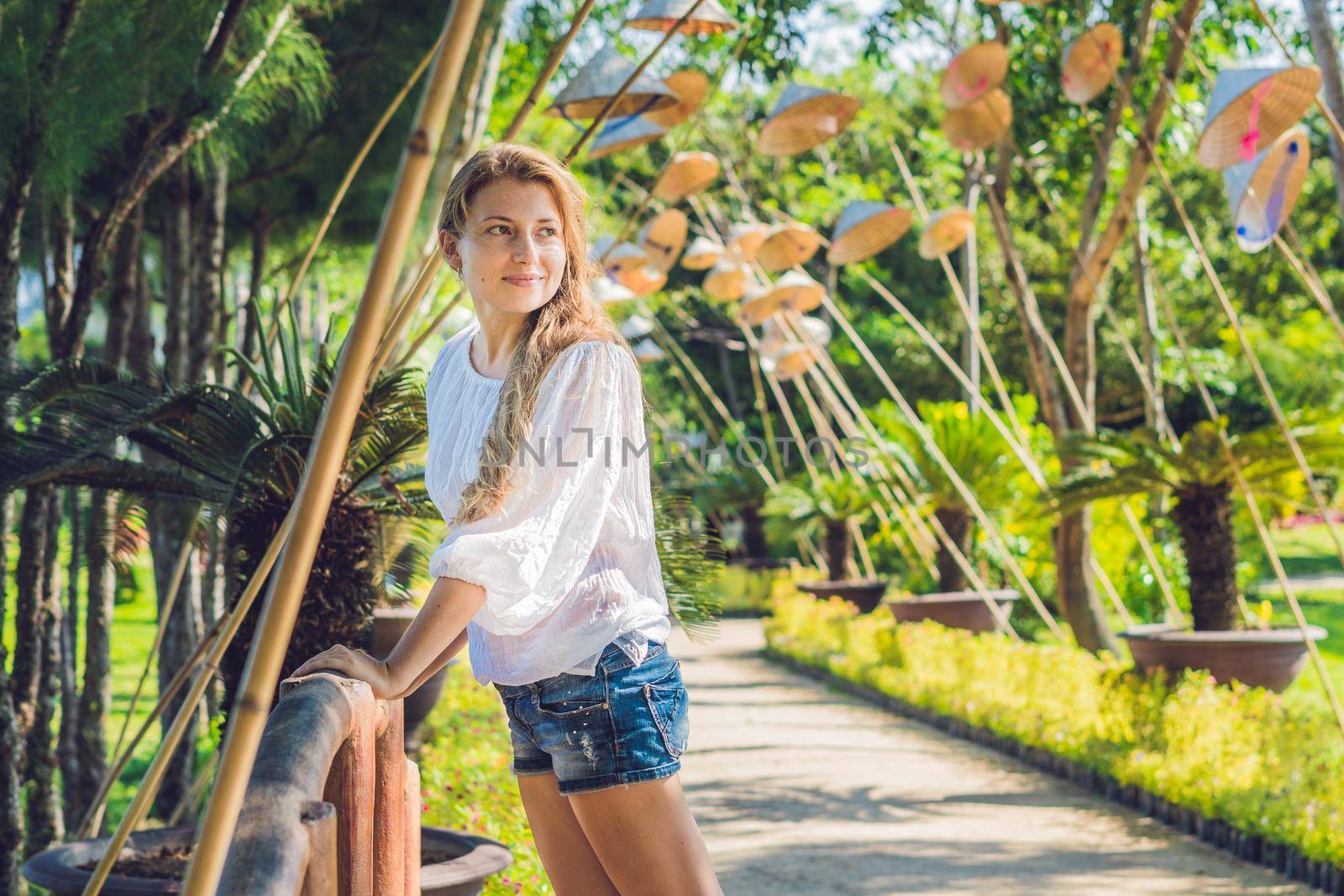 Young woman tourist and Vietnamese hats. Travel around Vietnam concept.