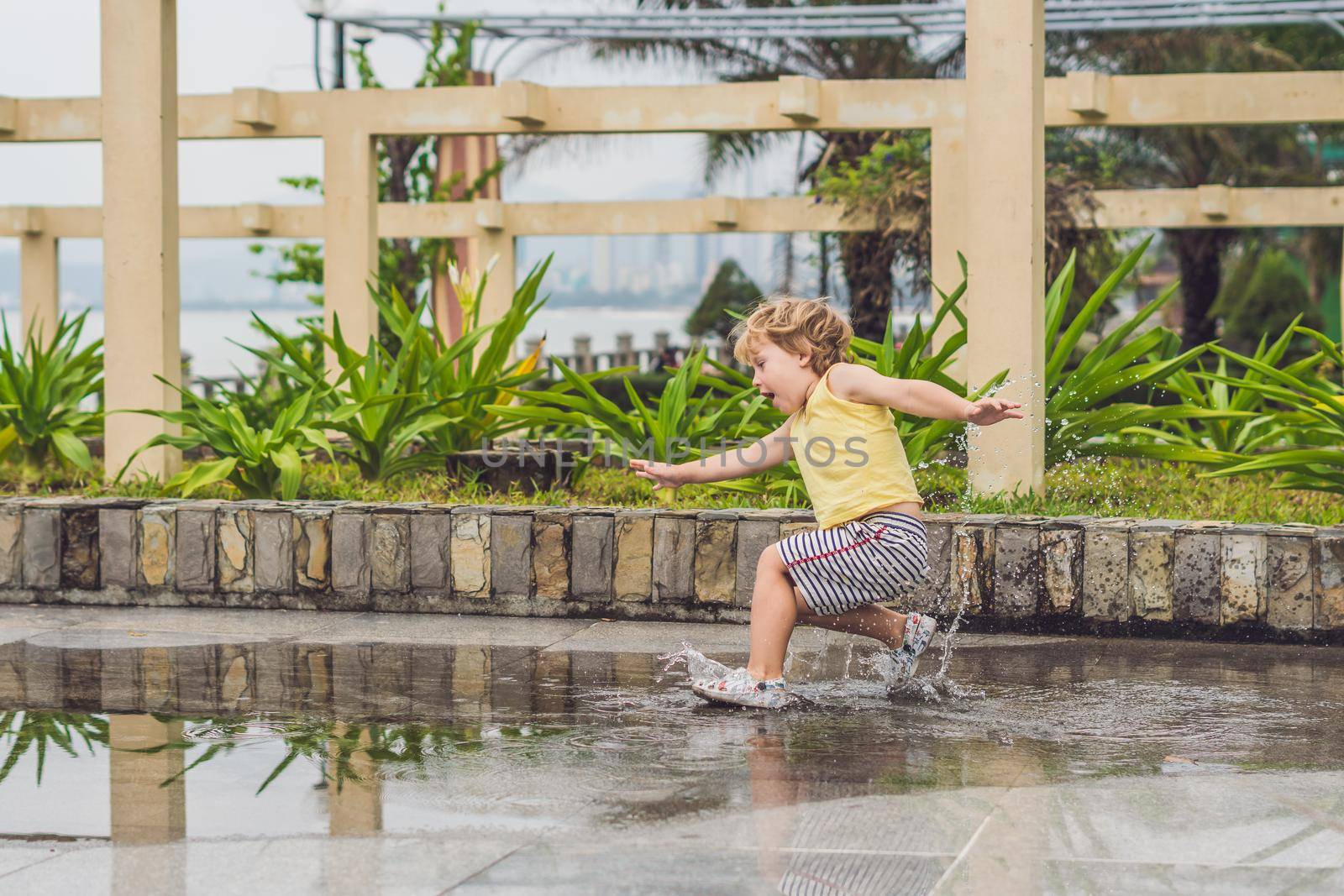 Little boy runs through a puddle. summer outdoor.