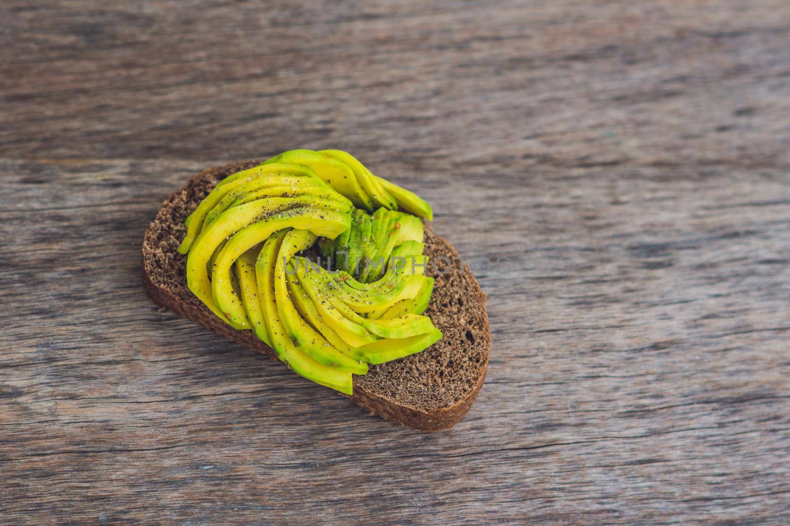 Avocado sandwich on dark rye bread made with fresh sliced avocados.