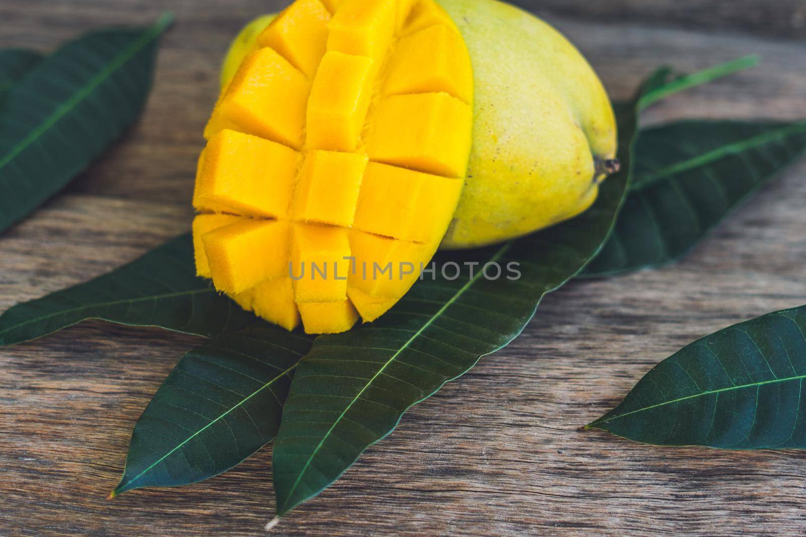 Mango and mango leaves on an old wooden background.