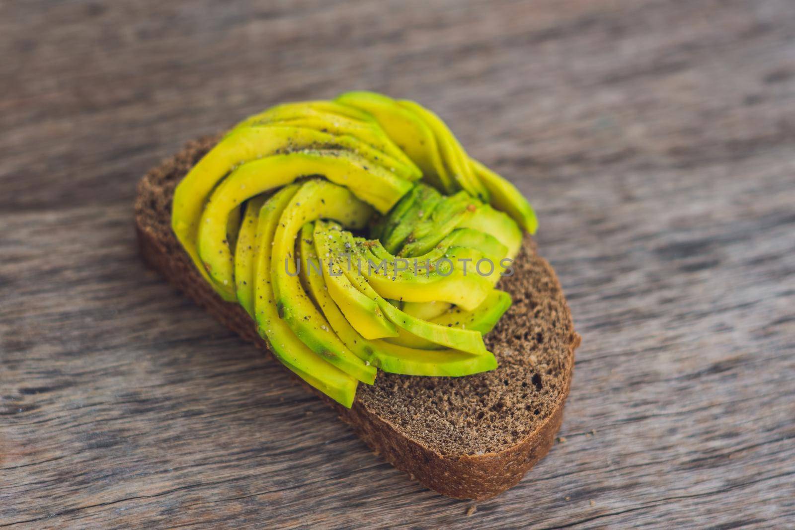 Avocado sandwich on dark rye bread made with fresh sliced avocados by galitskaya