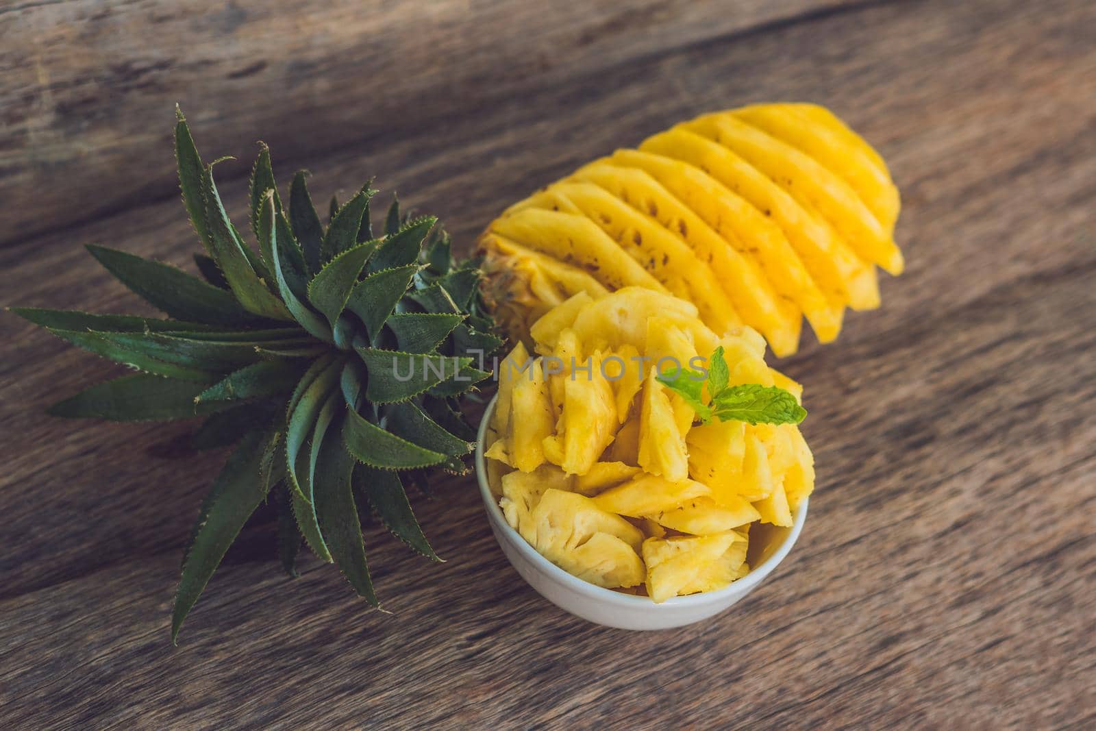 Pineapple and pineapple slices on an old wooden background.