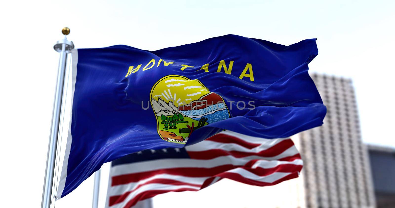 the flag of the US state of Montana waving in the wind with the American flag blurred in the background by rarrarorro
