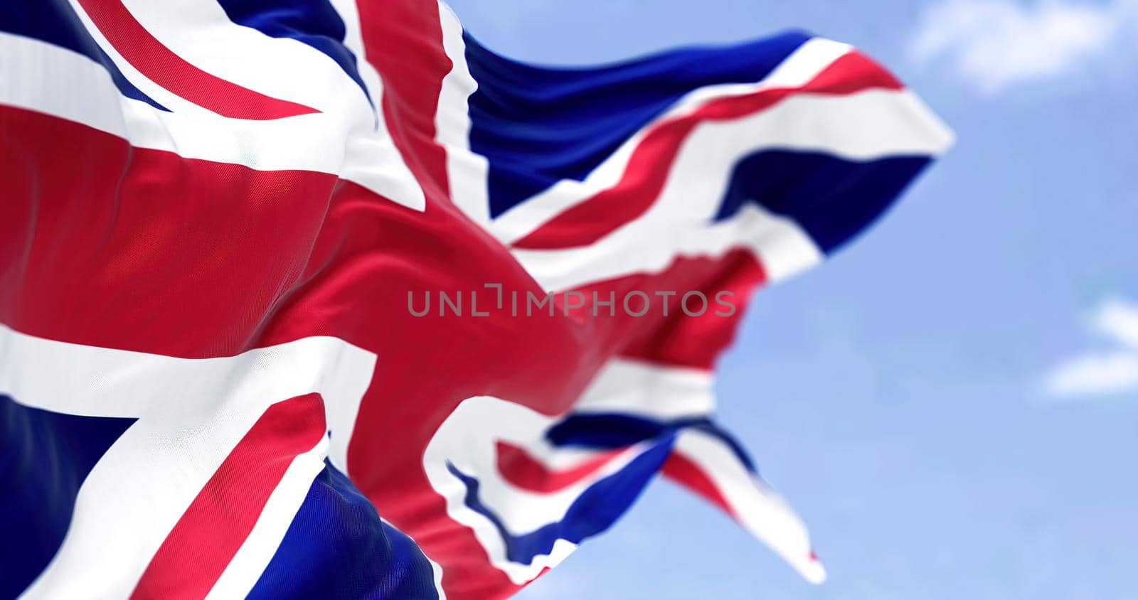 Three national flag of the United Kingdom flying in the wind on a bright day. Selective focus