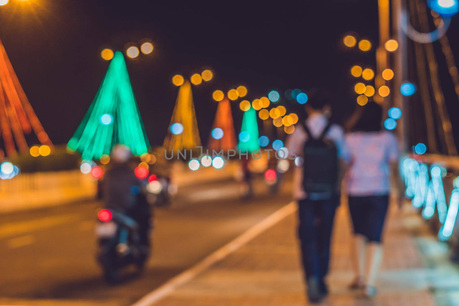 Young couple on the background Busy traffic on a bridge at night. Glowing bridge supports. Blurred focus.