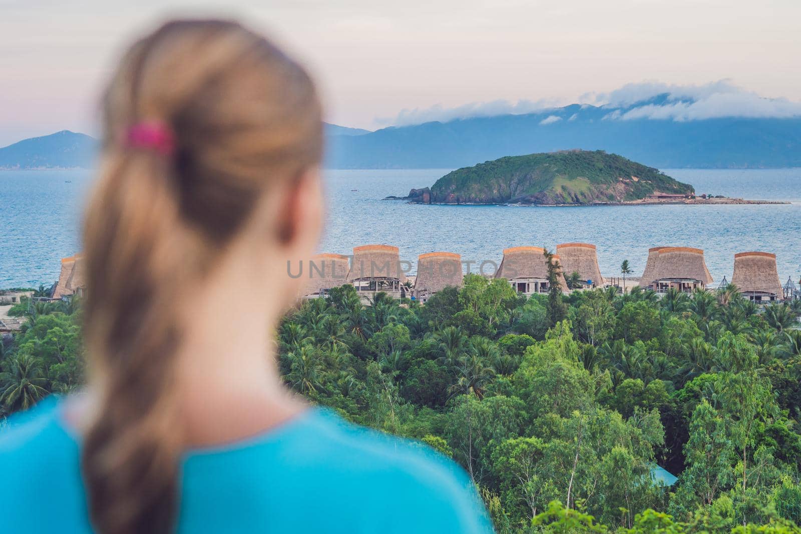 A young woman looks at the sea. Focus on the sea.