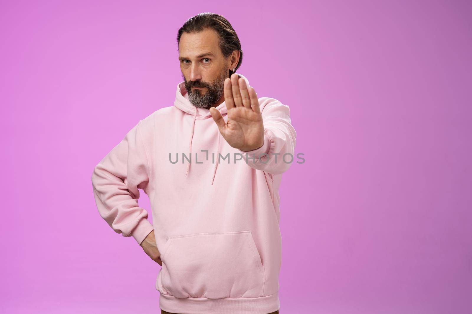 Stand right there. Portrait serious-looking bossy adult bearded father extend arm stop taboo no gesture forbidding come party look solid confident demanding quit, standing purple background.