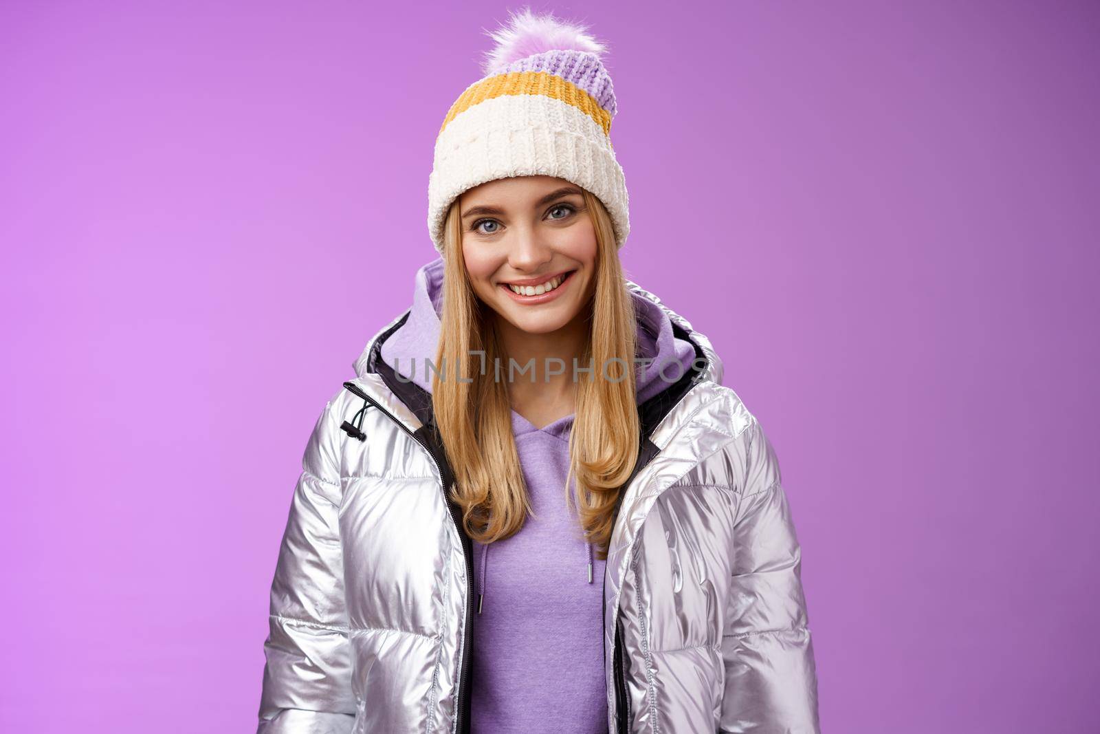 Cute young blond european woman wearing warm cozy jacket hat ski resort vacation having fun smiling amused rent equipment wanna learn snowboarding standing happily purple background by Benzoix