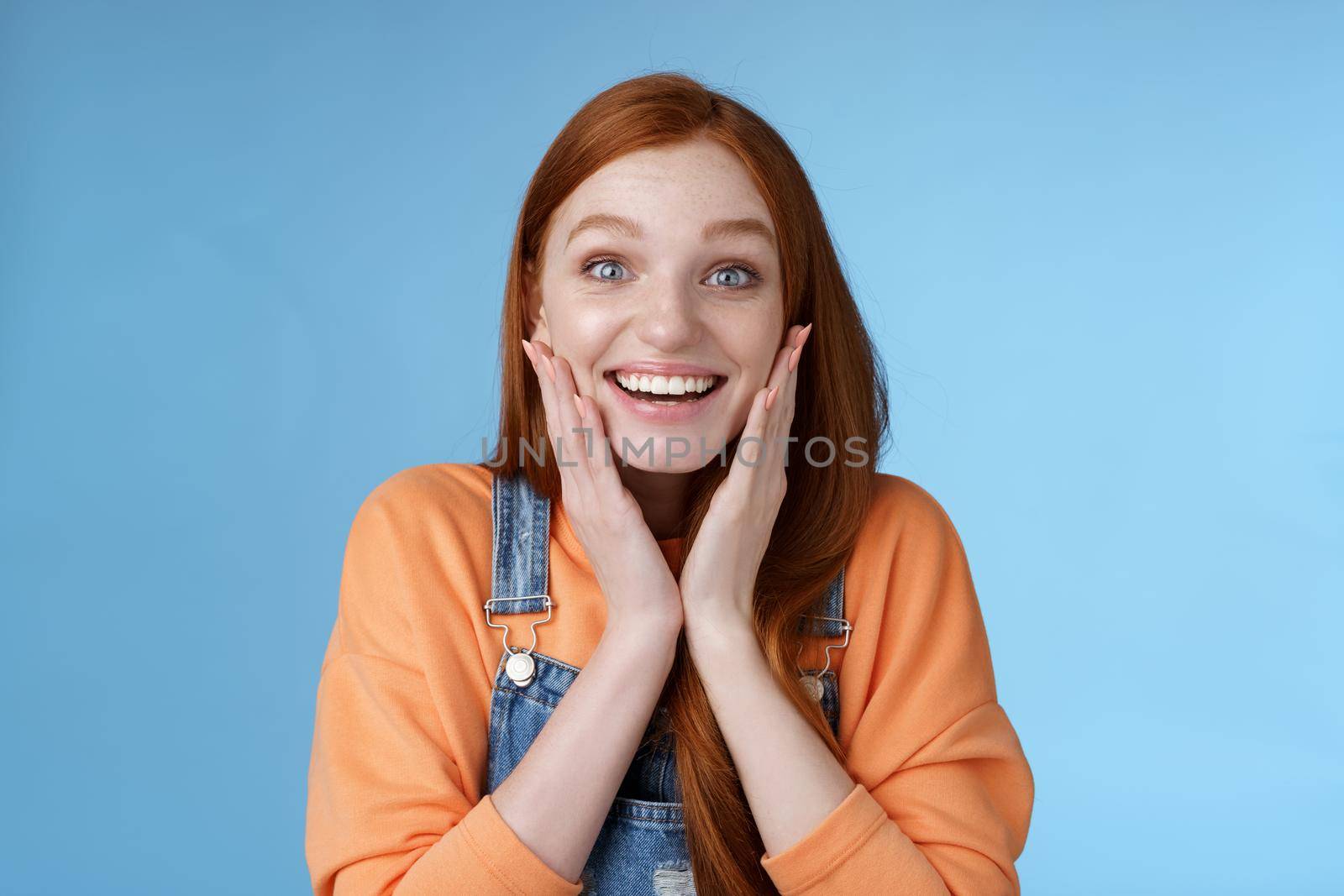 Amused cheerful surprised young attractive daughter receive car b-day present standing astonished speechless look joyful camera touch cheeks excitement smiling broadly, blue background by Benzoix