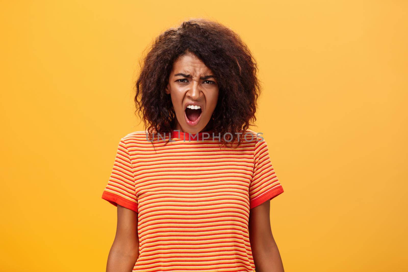Not fair you broke promise. Portrait of offended displeased moody african american girlfriend with curly hair yelling and complaining making displeased grimace shouting at camera from offence. Emotions concept