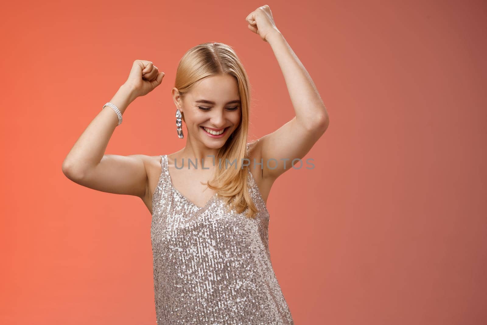 Joyful blond excited birthday girl having fun carefree dancing raised hands close eyes smiling enjoying night-out girlfriend nightclub have fun standing amused red background entertained.