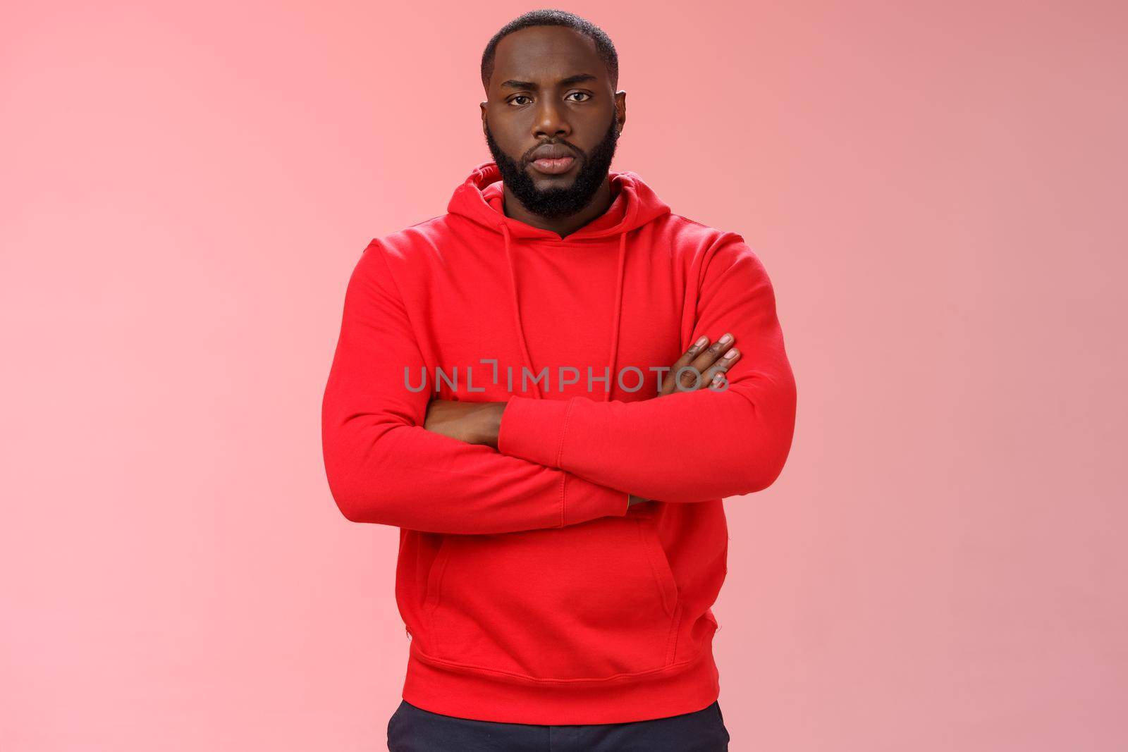 Serious-looking strong black guy security worker cross hands chest confident bossy pose frowning making solid scary look wearing red hooide posing red background, employer controling work by Benzoix