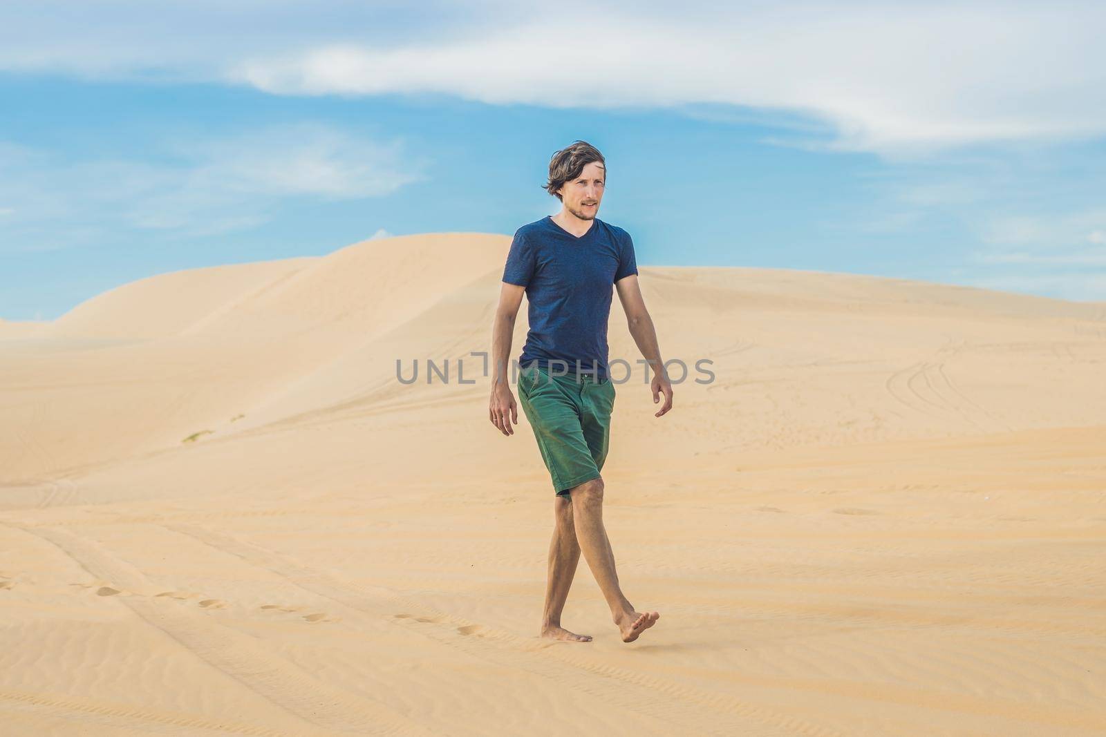 A man is walking in the desert Vietnam, Mui Ne by galitskaya