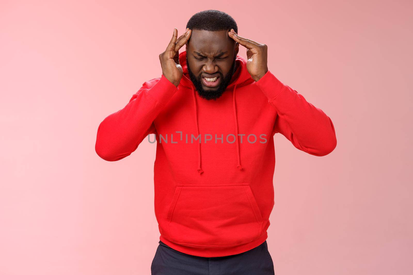 Frustrated pressured stressed-out young african-american businessman frowning cringing painful feeling holding hands head temples suffer miragine bothering headache, standing pink background by Benzoix