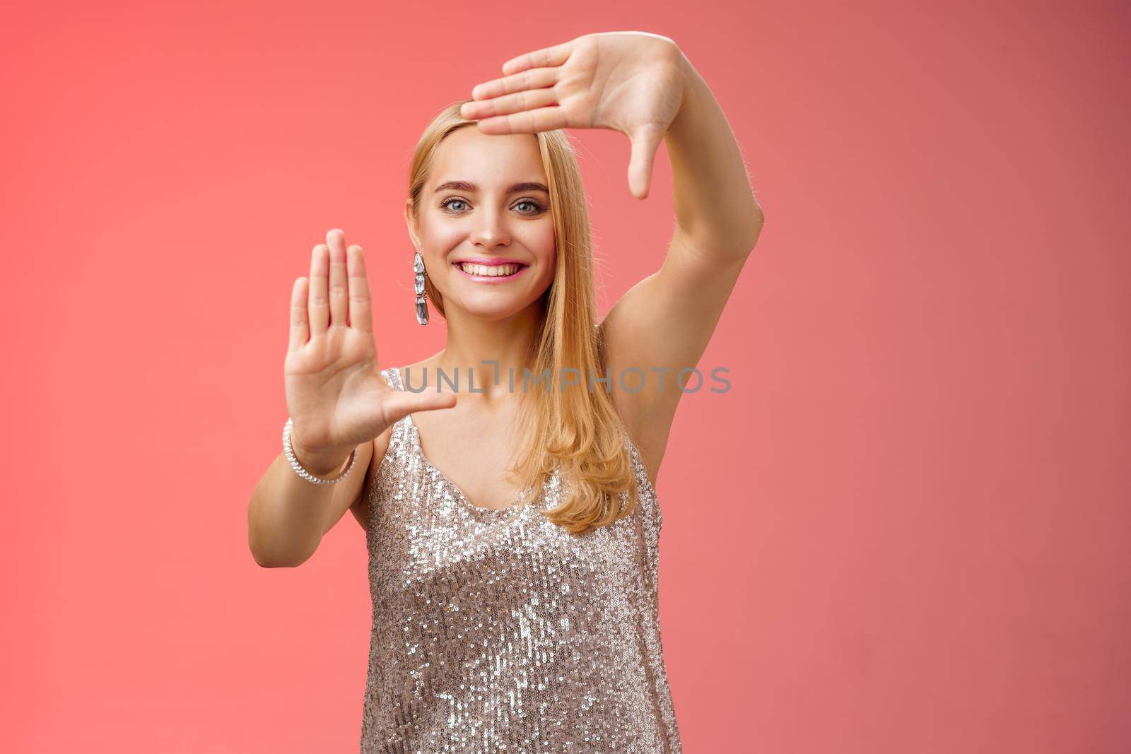 Charming creative young elegant blond female photographer blogger search inspiration picking right angle take cool shot making frames hands smiling broadly look through, red background by Benzoix