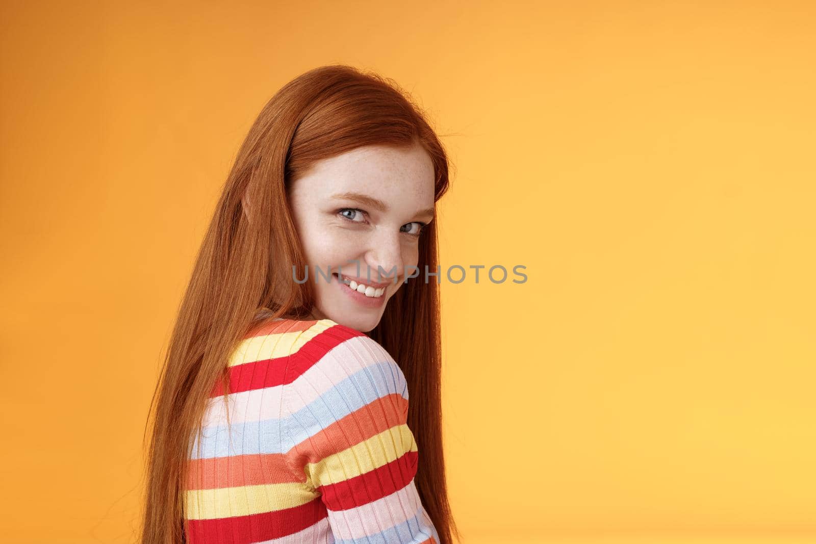 Tenderness, romance, seduction concept. Attractive cheeky flirty young redhead daring girl turn behind look shoulder camera smiling silly coquettish giggle express sympathy affection.