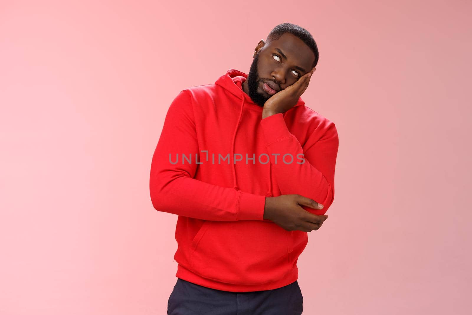 Annoyed bored funny attractive african american guy in red hoodie roll eyelids facepalm head lean hand, hear stupid uninteresting story dying boredom, standing careless rude pink background by Benzoix