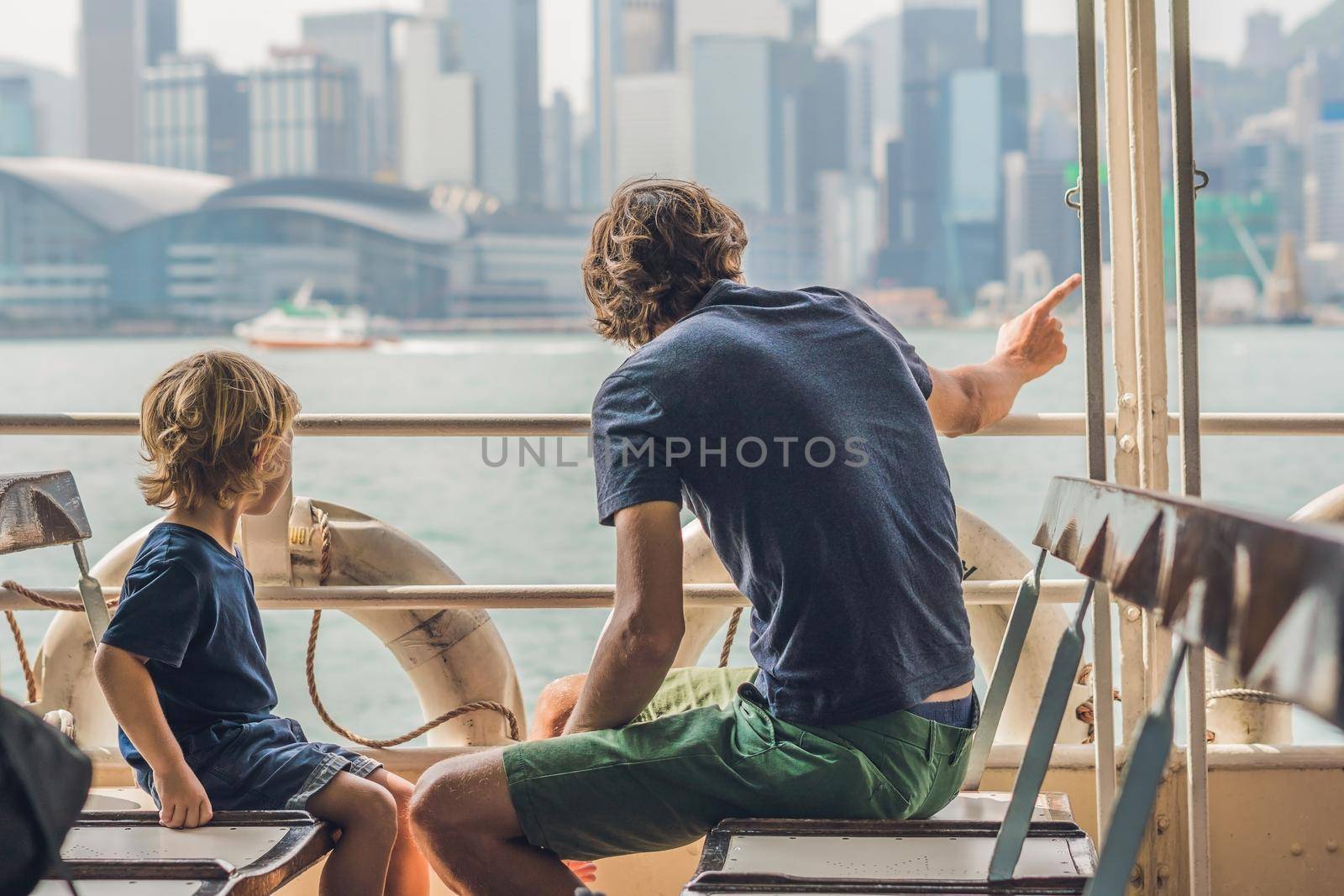Father and son swim by ferry through victoria harbor in Hong Kong,China.