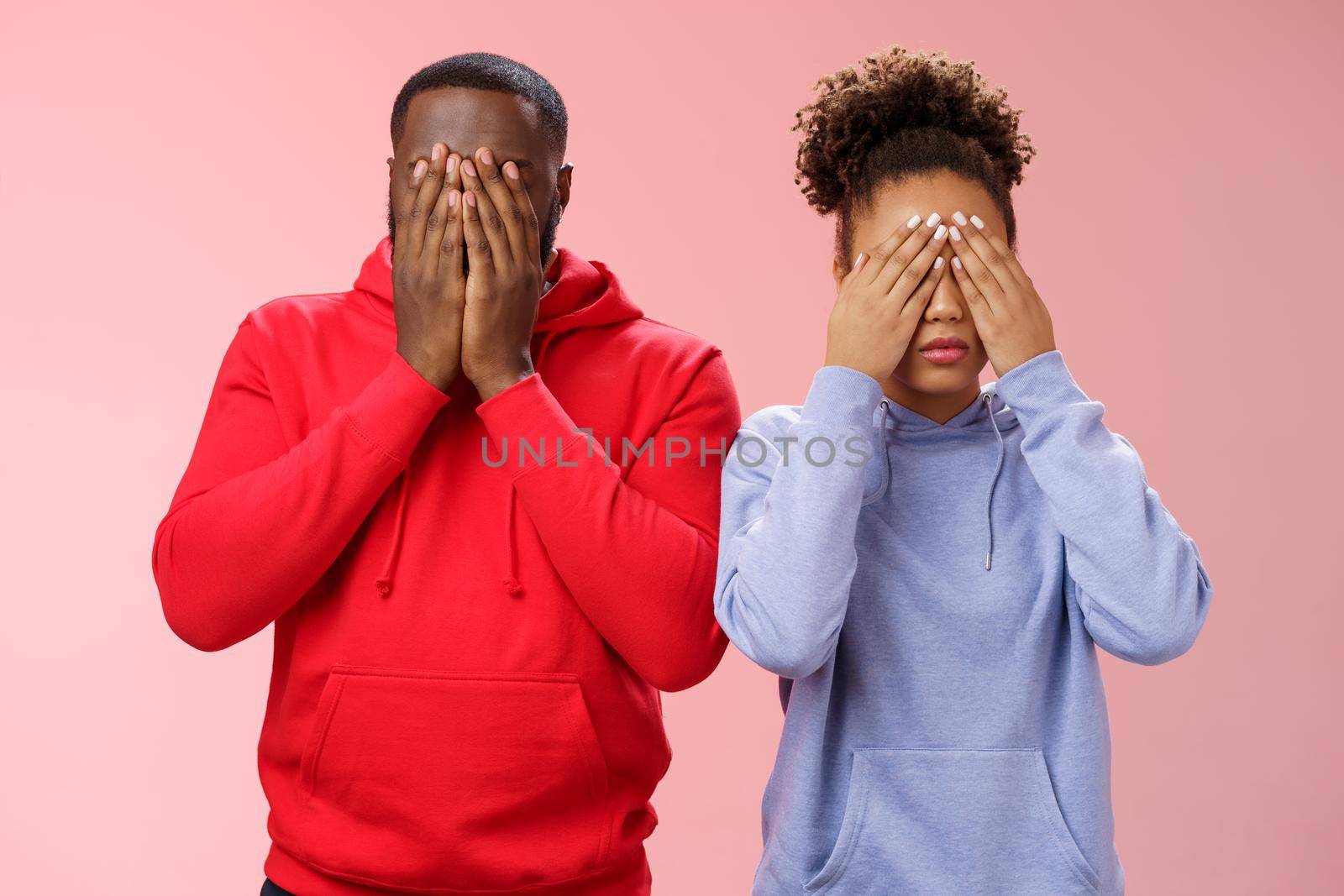 Two african-american man woman standing pink background hide faces close eyes palms tired looking lies upset waiting sign command see, playing hide-n-seek, unwilling spot personal problems by Benzoix