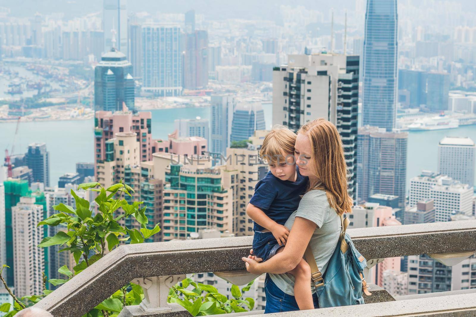 Mom and son travelers at the peak of Victoria against the backdrop of Hong Kong. Traveling with children concept.