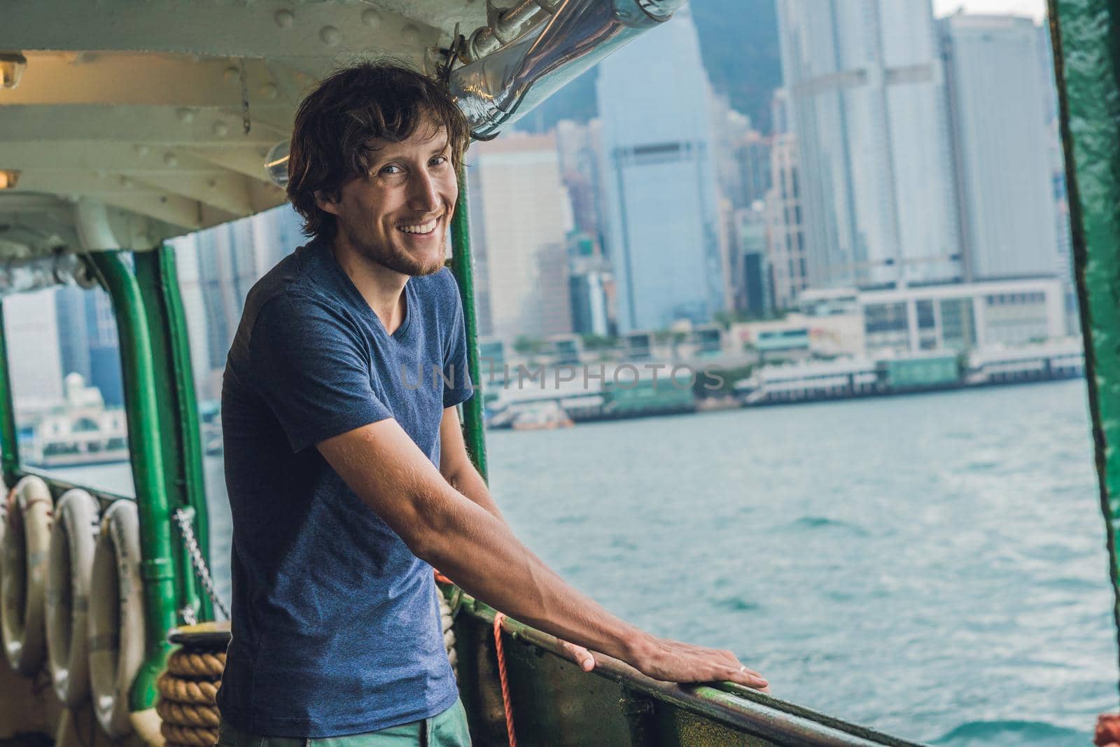 A young man on a ferry in Hong Kong by galitskaya