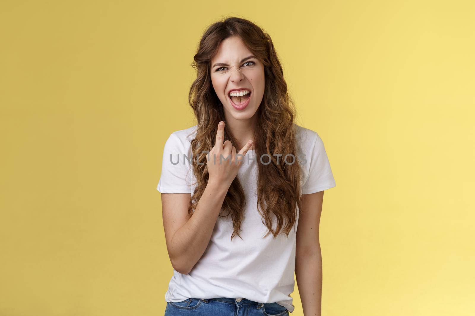 Oh yes fire up party awesome. Joyful daring good-looking sassy caucasian female music festival fun having fun enjoy cool heavy-metal concert grimacing confident stand yellow background.